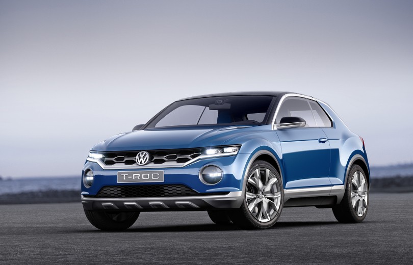 Blå Volkswagen T-ROC SUV set fra siden på asfaltvej med grå himmel i baggrund
