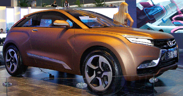 Orange-brun Mitsubishi SUV udstillet udendørs med åben motorhjelm og blå banner i baggrunden